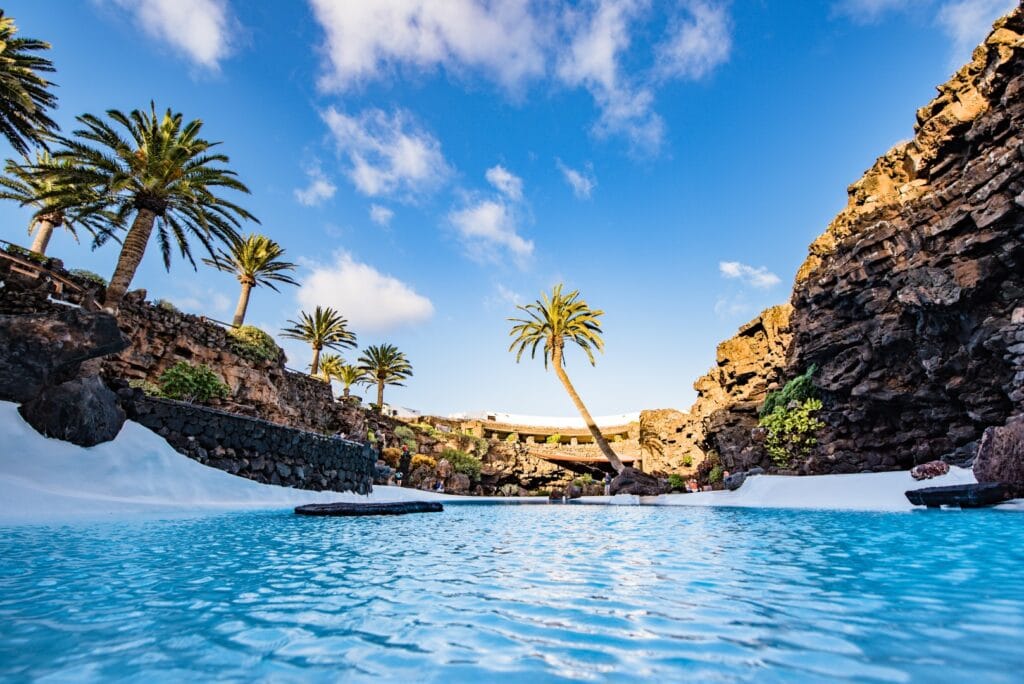 La piscina turchese dei Jameos del Agua tra palme e pareti di lava
